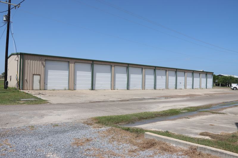 The Boat Barn boat and RV storage building with white roll-up bay doors on East Port Drive in Port Mansfield, Texas